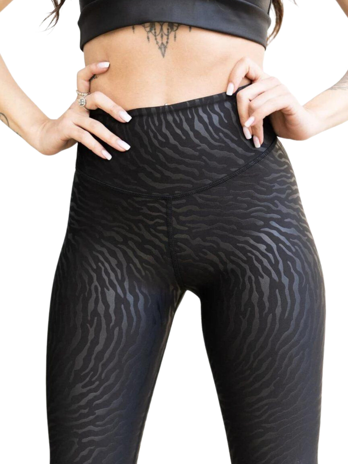 Individuell in Lisminas 1194 Leder-Look-Leggings in Schwarz und einem bauchfreien Top, das ein Bauchtattoo enthüllt.