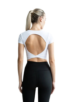 Person in schwarzen Leggings und einem Lismina 094 Larissa Sport Top in Weiss, offenes Rückendesign, mit abgewandtem Blick.