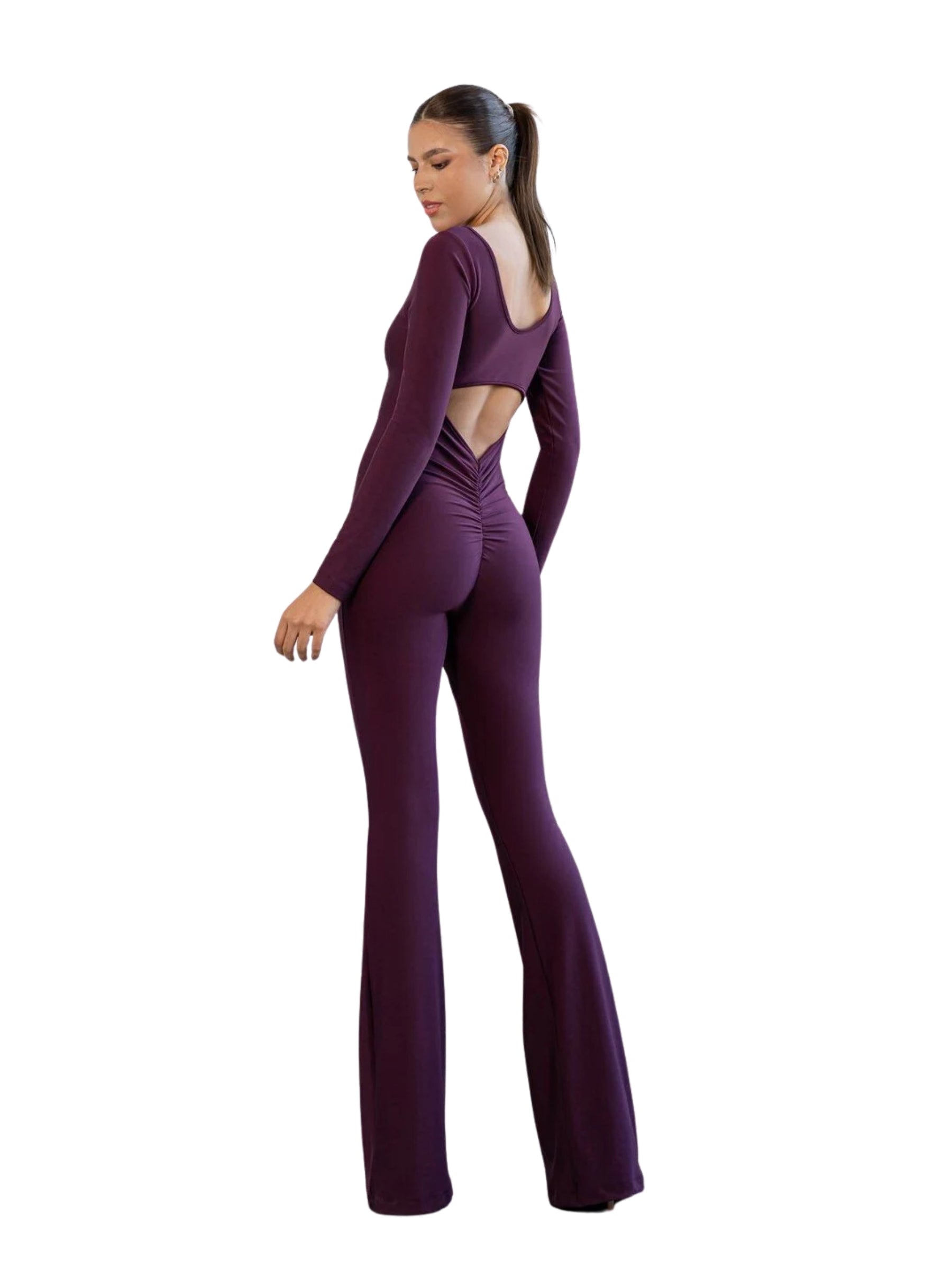 Frau in einem Lismina 3102 Spanish Scrunch Butt Jumpsuit in Violett, stehend und über ihre Schulter blickend.