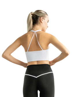 Person mit Pferdeschwanz, in Lisminas 392 Saintes Sport-BH in Weiss und schwarzen Leggings, konzentriert auf Yoga-Fitness, von hinten betrachtet.