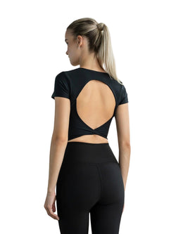 Frau mit Pferdeschwanz trägt Lisminas 093 Larissa Sport Top in Schwarz mit offenem Rücken vor weißem Hintergrund.