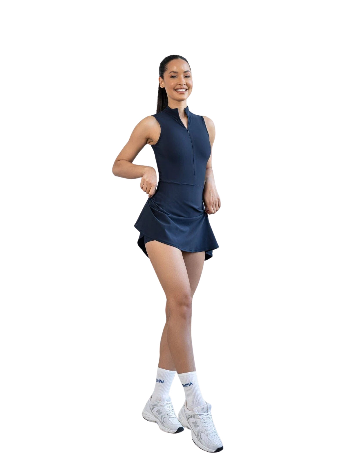 Frau im Lismina 3054 Jumpsuit in Marineblau, strahlend lächelnd mit weißen Socken und Sneakers.