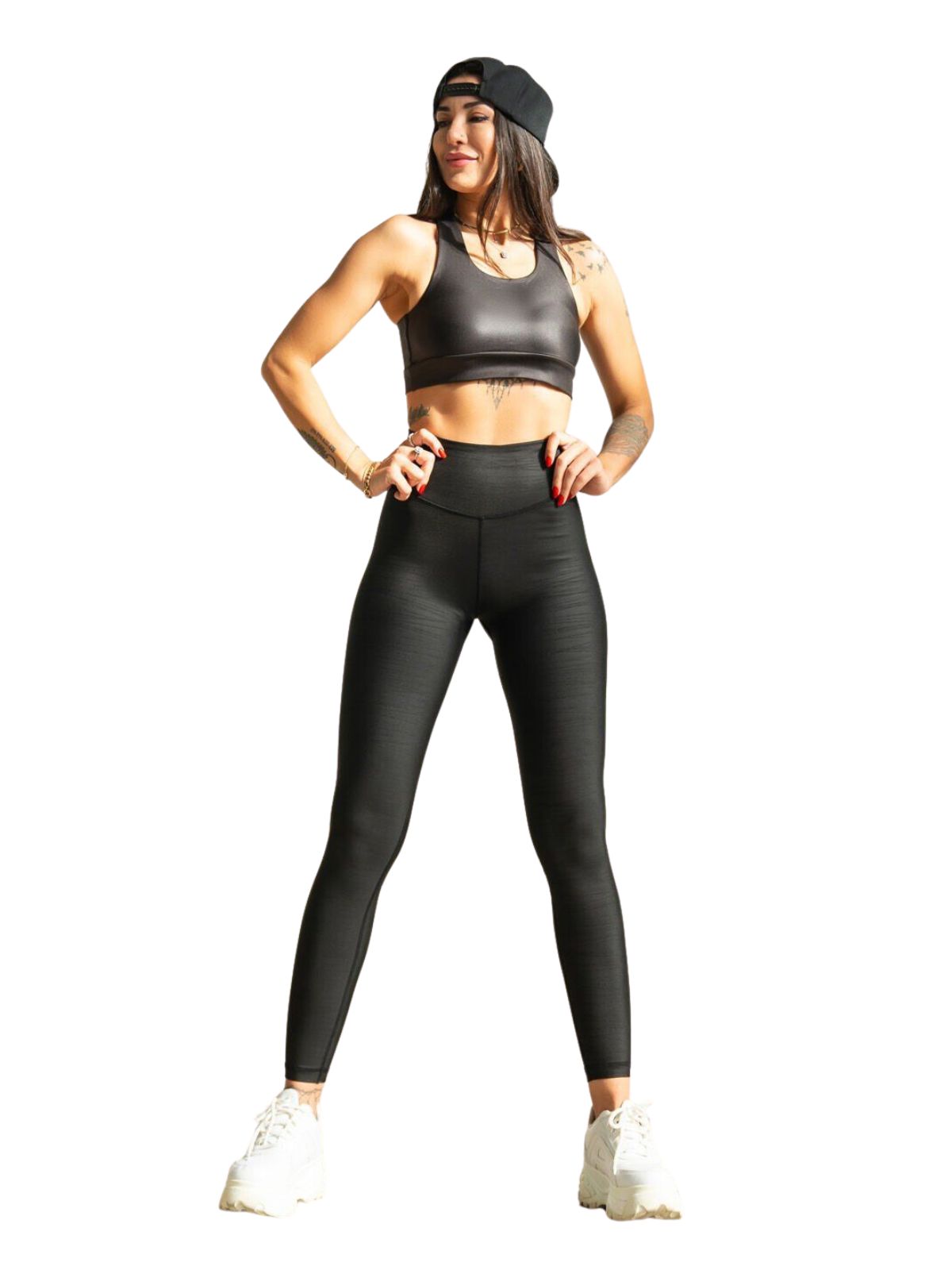 Fitnessmodel Lismina in 347 Scratch Detailed Leather Look Leggings, schwarzen Sneakers, Mütze, Hände in den Hüften.