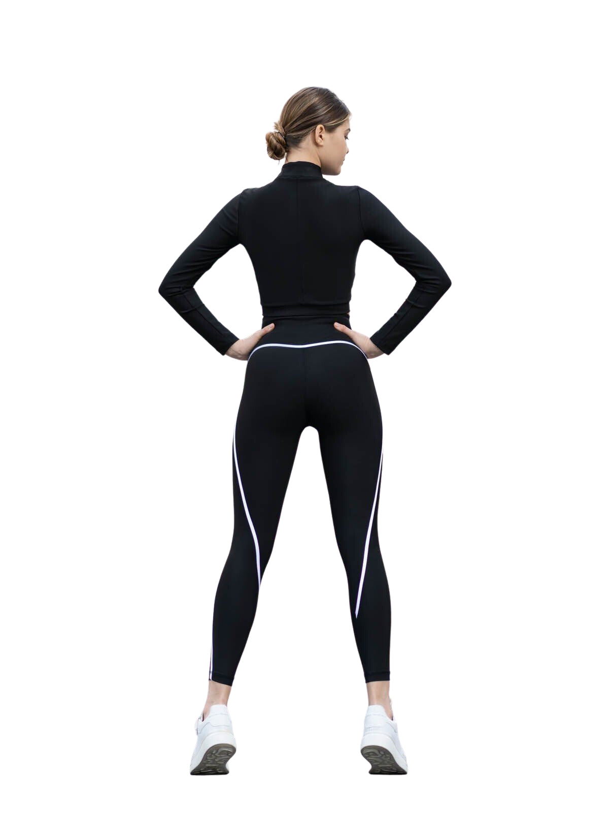 Person in Lismina 352 Menton Leggings, schwarzen Leggings und weißen Sneakers stehend, mit Händen auf den Hüften.