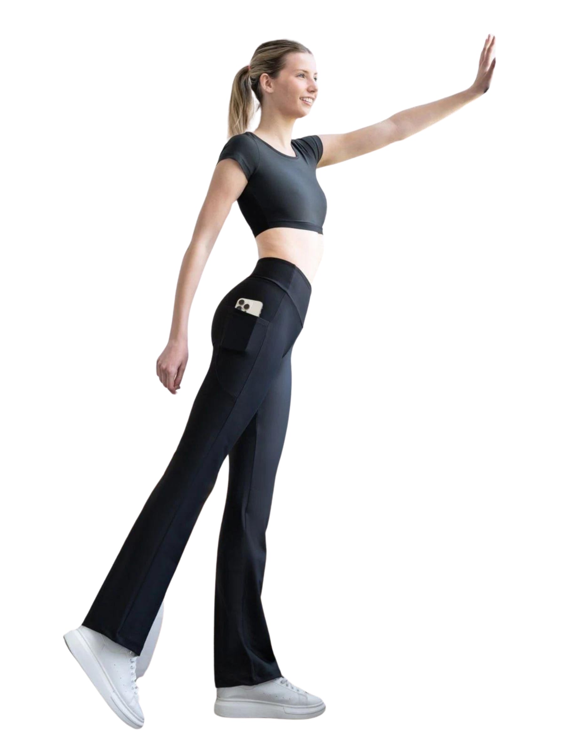 Frau trägt Lisminas 432 Pocket Schlagleggings in Schwarz, steht seitlich mit erhobenem Arm.