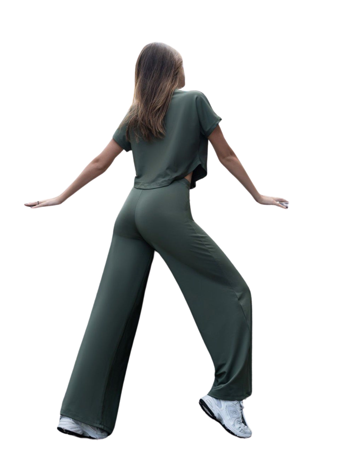 Person in Lisminas 098 Yoga T-Shirt Khaki, mit ausgestreckten Armen, die mit weißen Turnschuhen Yoga-inspirierten Komfort ausstrahlt.