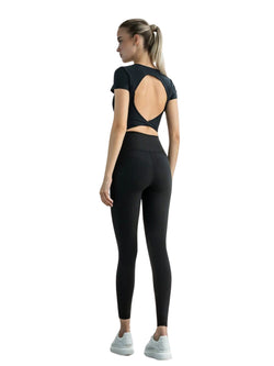 Frau in schwarzem Lismina 093 Larissa Sport Top und Leggings mit weißen Sneakers, seitlich stehend.