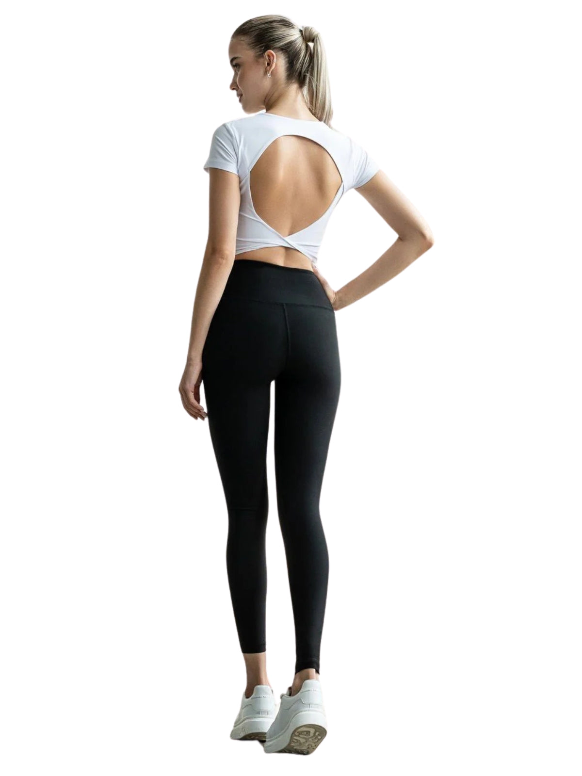 Person trägt ein Lismina 094 Larissa Sport Top in Weiss, schwarze Leggings und weiße Sneakers, ideal für ein Fitness-Workout.