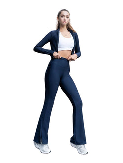 Person in marineblauen Lismina 1259 Split Spanish Leggings, weißem Sport-BH, blauer Jacke und weißen Turnschuhen steht selbstbewusst da.
