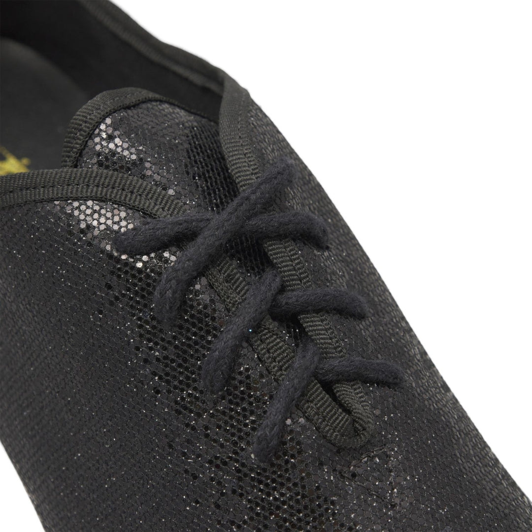 Nahaufnahme eines schwarzen JZE79 So Danca Jazzschuhes mit Pailletten von Rumpf mit glänzendem Material und schwarzen Schnürsenkeln.