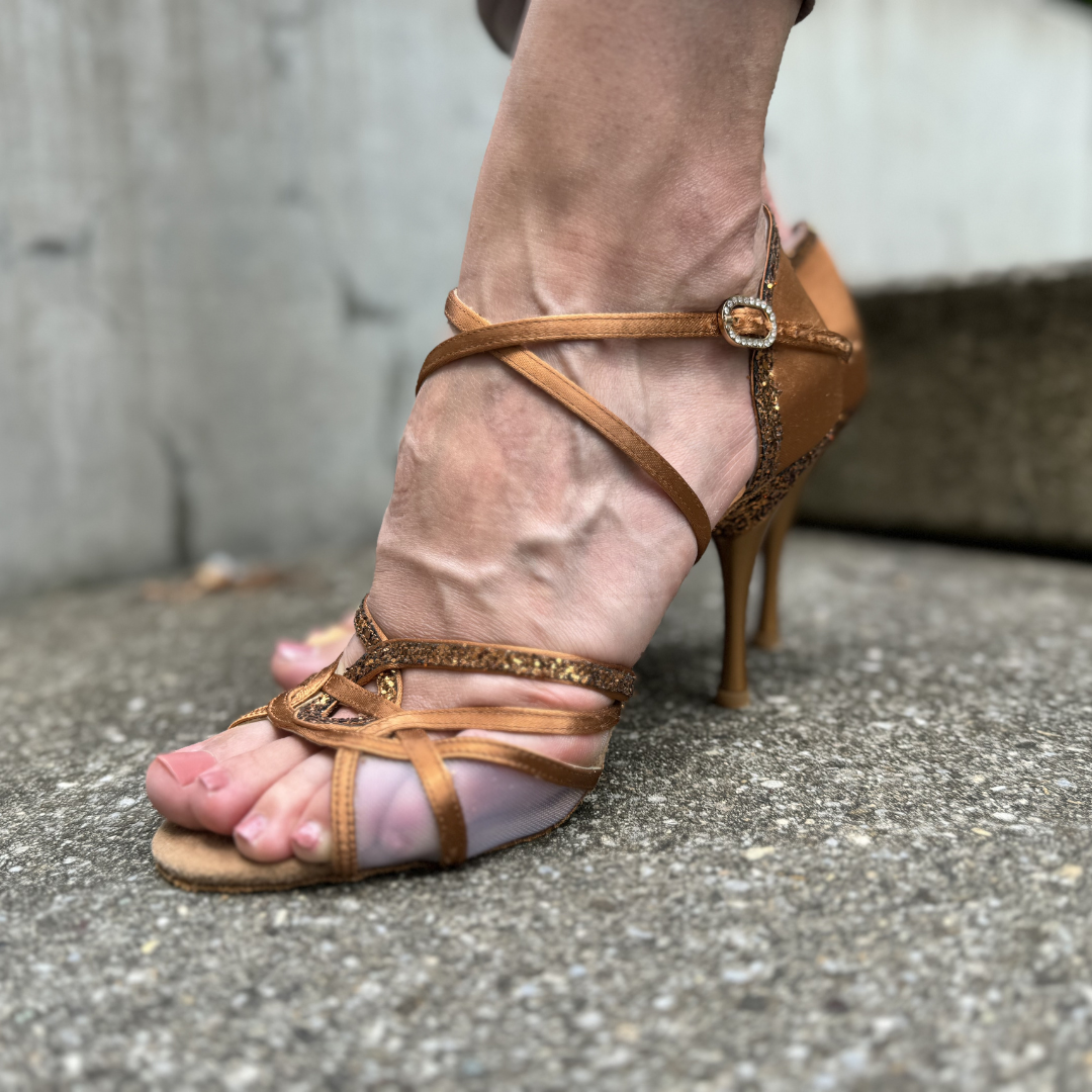 Nahaufnahme eines Fußes in Portdance PD800 Net Tanzschuhen, Bronze Dark Satin, auf einer Betonoberfläche.