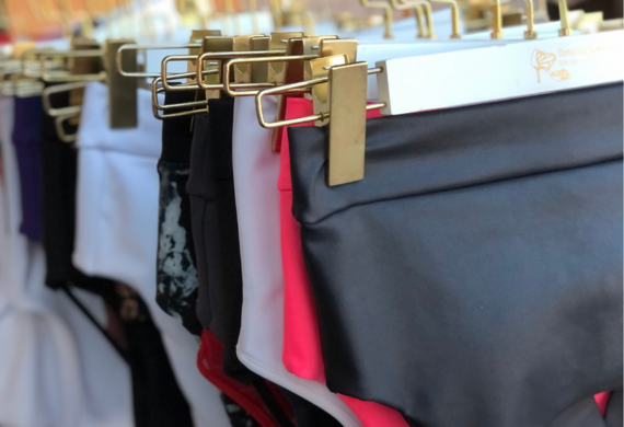 Mehrere Paar bunte Unterwäsche hängen auf goldenen Kleiderbügeln in einer Ladenauslage.