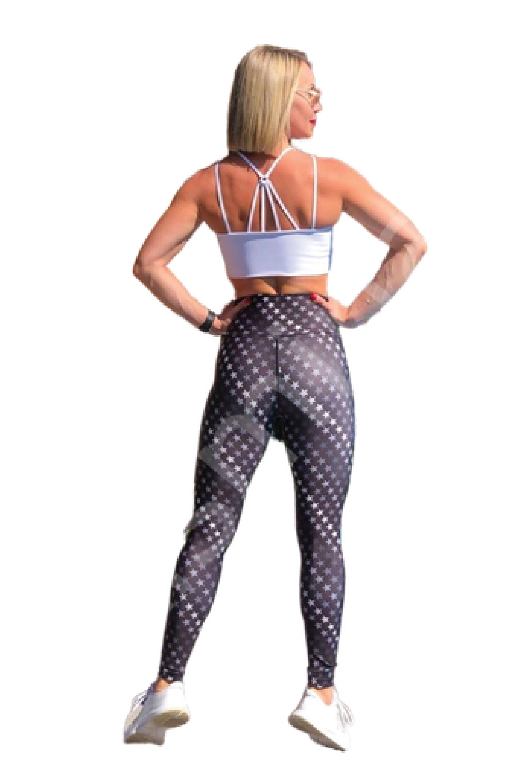 Person in Trainingskleidung, die Lisminas 121 Sport-BH in Weiss, geometrische Leggings, Turnschuhe und eine Sport-Sonnenbrille trägt.