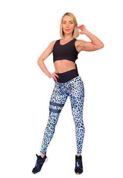 Selbstbewusste Frau in Lisminas schwarzem Top und 903 Extra High Waist Leggings in Leopard, Hand auf der Hüfte, weißer Hintergrund.