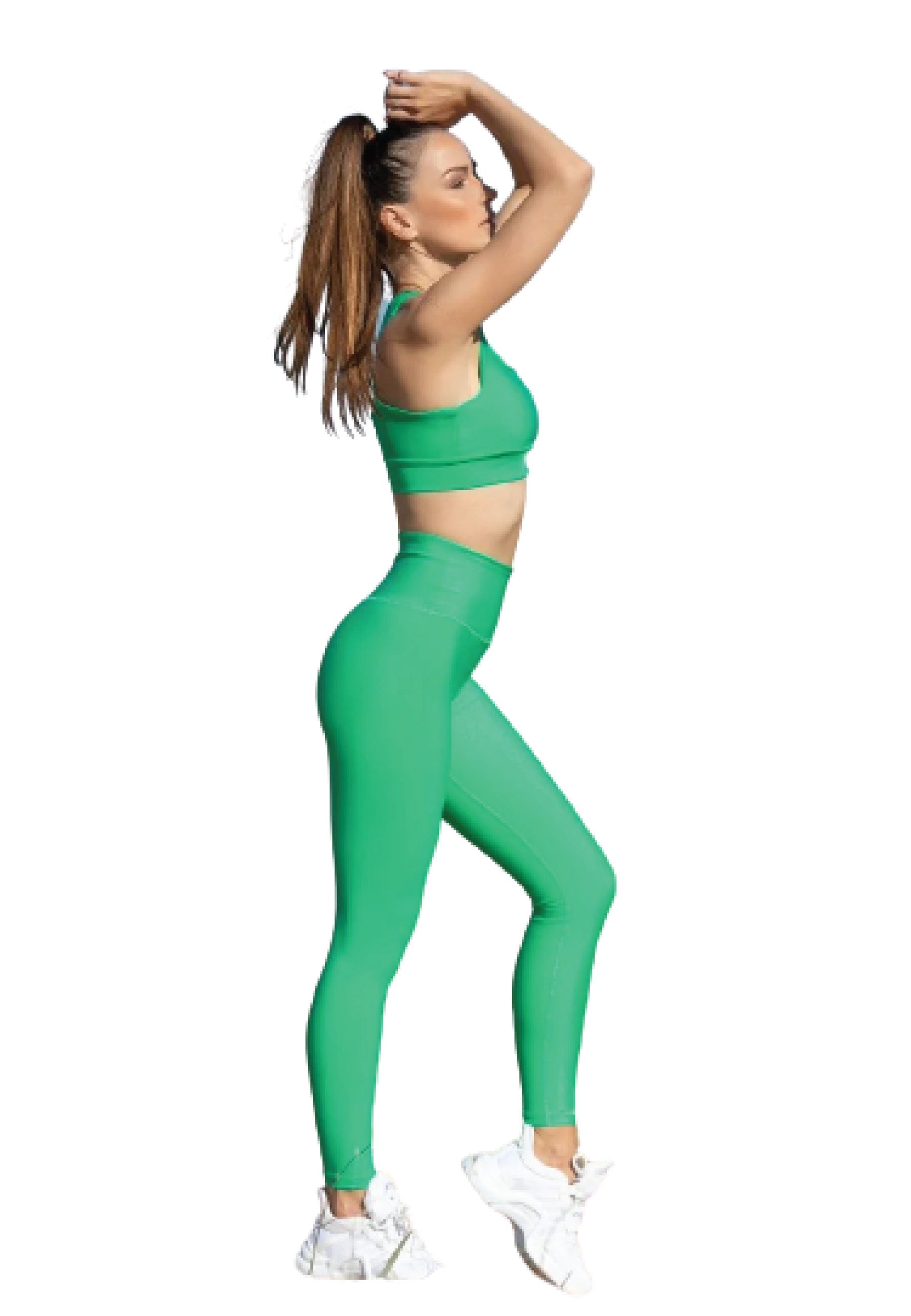 Frau in einem Lismina 185 Single Crossed Sport-BH in Grün und Turnschuhen posiert, Arme über dem Kopf, Haare im Pferdeschwanz.