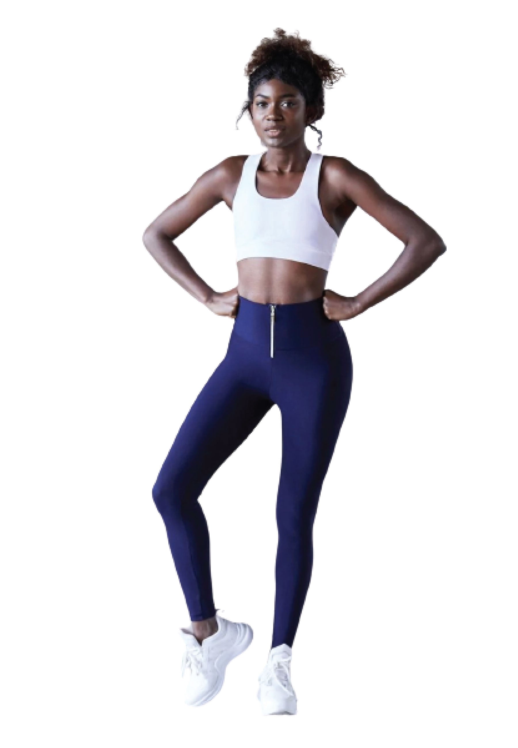 Eine Frau steht selbstbewusst mit den Händen in den Hüften und trägt Lisminas 1050 Zipper Leggings in Marineblau und weiße Turnschuhe.