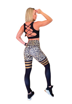 Eine Person in Lisminas schwarzem Oberteil mit gekreuztem Rücken und 893 Extra High Waist Leggings in Leopardenmuster posiert mit einer Hand auf dem Kopf.