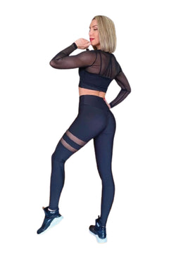Person in Lisminas 051 Tulle Look Top in Schwarz, mit schwarzer Sportkleidung und Turnschuhen vor weißem Hintergrund.