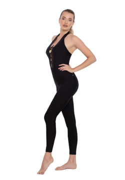 Eine Person, die den Esmeralda Lucia Jumpsuit in Schwarz trägt, steht seitlich und strahlt vor einem weißen Hintergrund Fitness-Vibes aus.