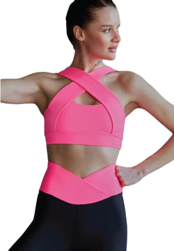 Eine Person in einem Lismina 193 Decoltée Sport-BH in rosa und schwarzen Leggings posiert vor einem weißen Hintergrund.