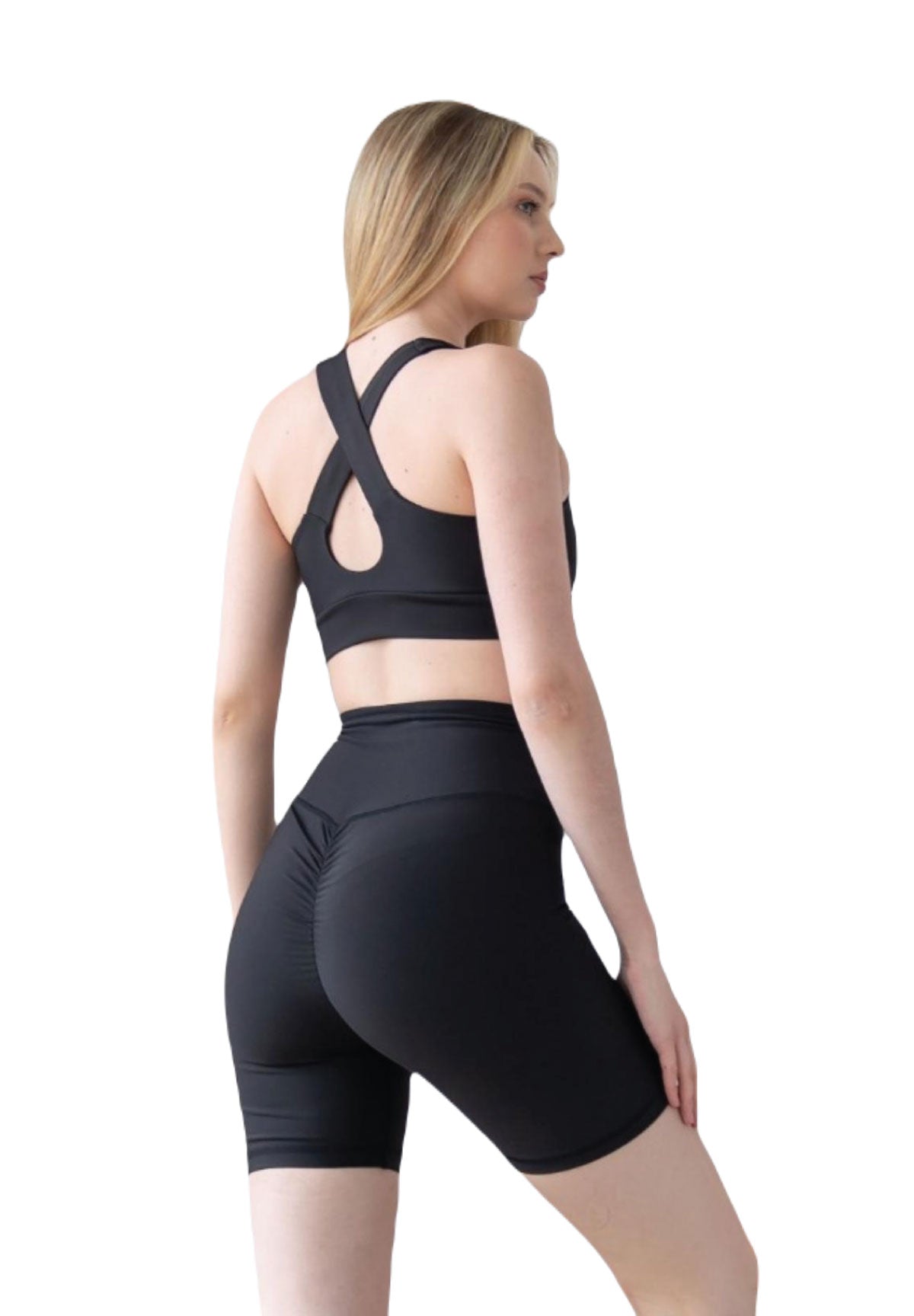 Frau in schwarzer Sportbekleidung von Lismina: Cross-Back-Top und 8000 Scrunch Butt Short in Schwarz, Blick zur Seite.