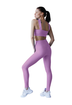 Model Lismina trägt 1044 Extra High Waist Leggings in Lila und weiße Sneakers, Seitenansicht.