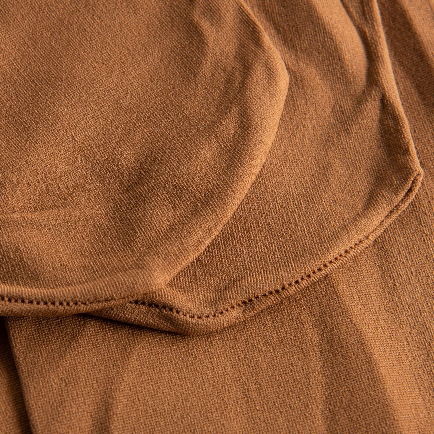Nahaufnahme eines hellbraunen Stoffes mit Struktur und Nähten, ähnlich der 108 Economy Ballettstrumpfhose von Rumpf in Noix.