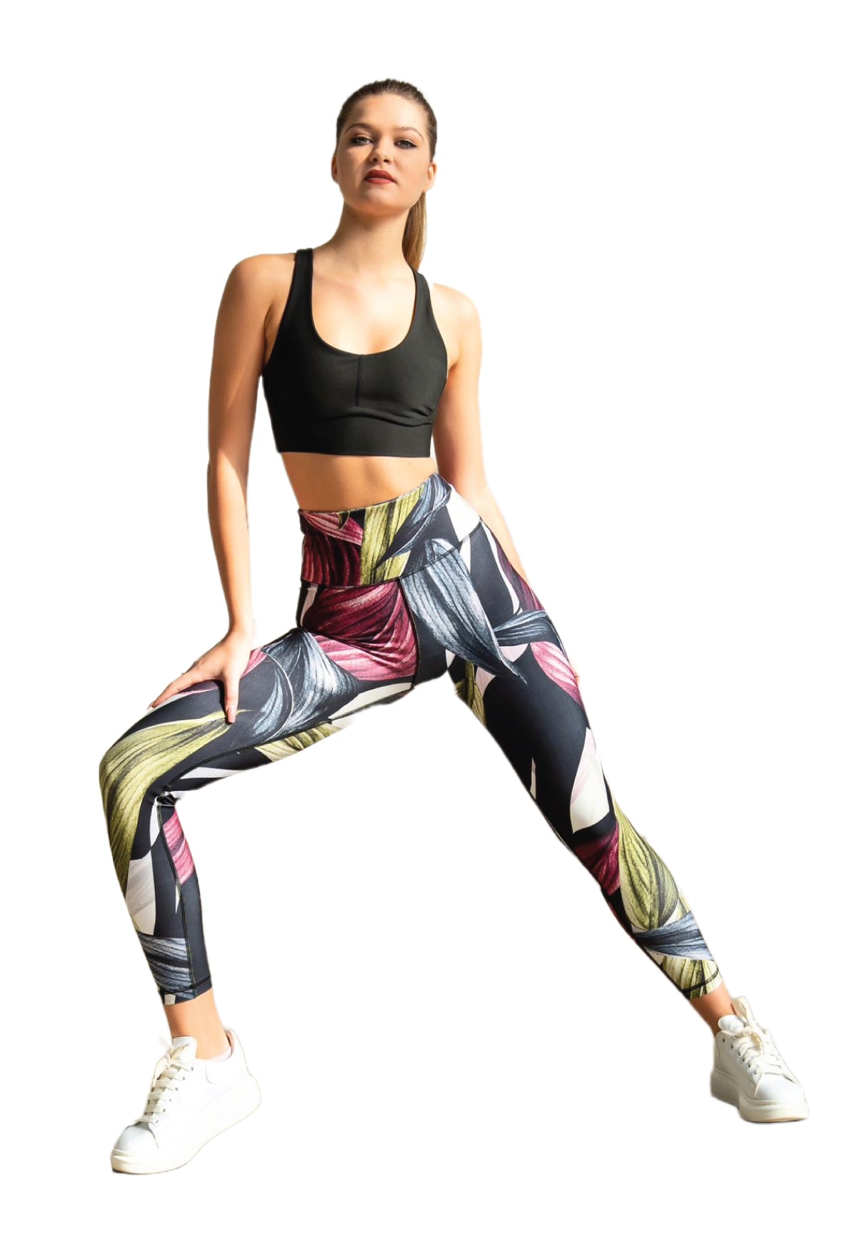 Person im schwarzen Lismina-Sport-BH und 324 Extra High Waist Leggings steht breitbeinig da und zelebriert den Sport vor weißem Hintergrund.