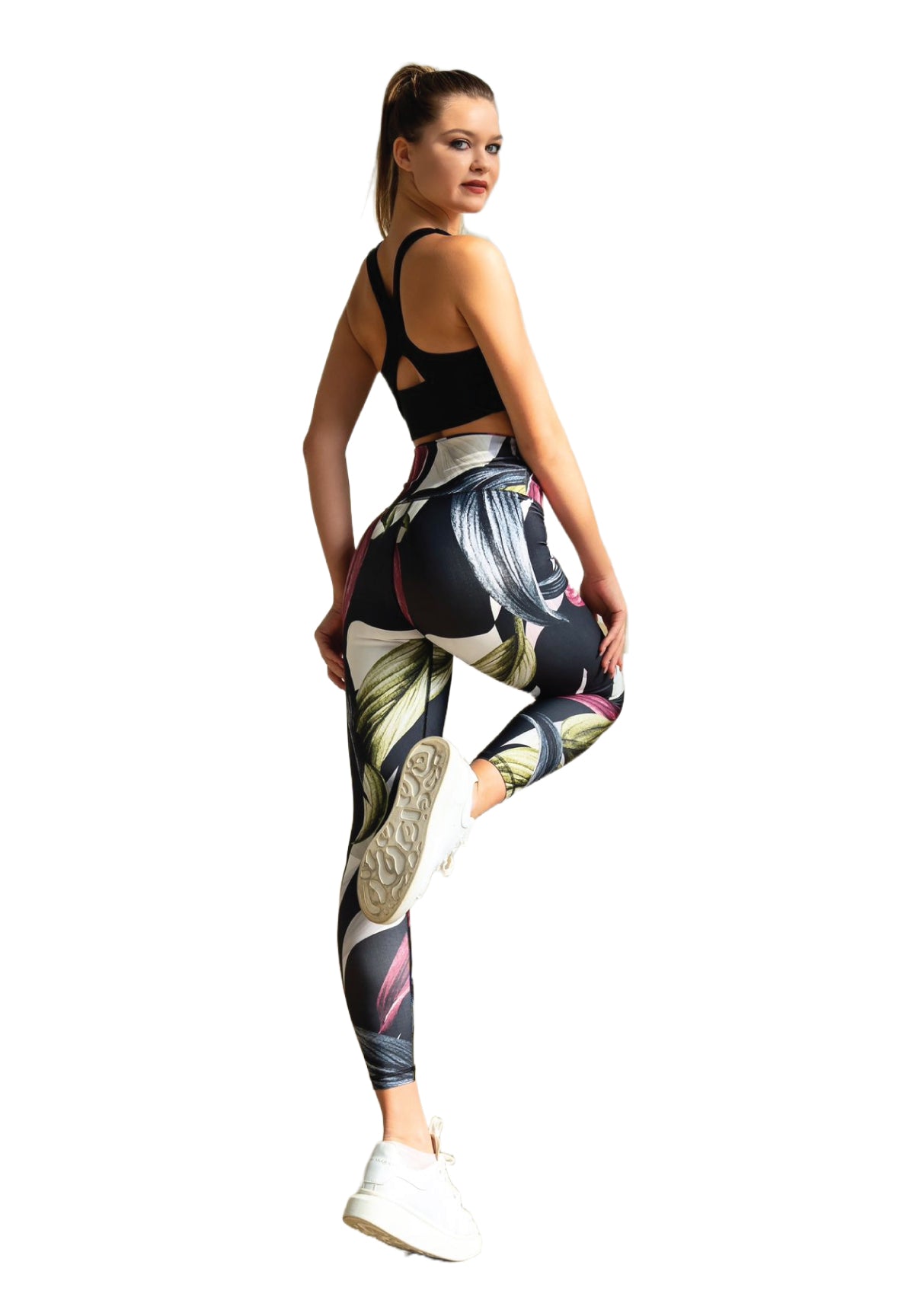 In den Lismina 324 Extra High Waist Leggings posiert eine Person mit einem angewinkelten Bein, trägt weiße Turnschuhe und einen schwarzen Sport-BH.