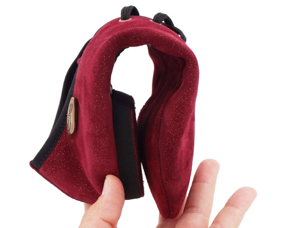 Eine Person hält einen bordeauxfarbenen Kletterkreidebeutel mit Kordelzug.