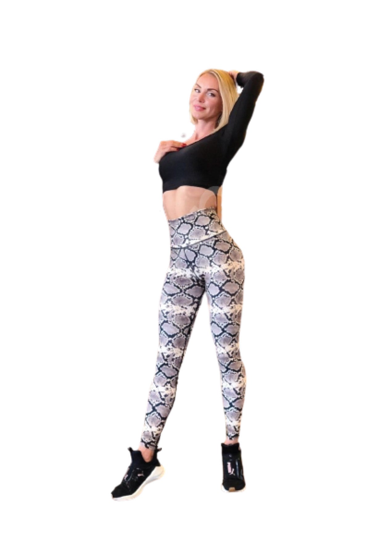 Person posiert in einem schwarzen bauchfreien Top und Lisminas 261 Extra High Waist Green Snake Leggings, Hand auf dem Kopf vor Weiß.