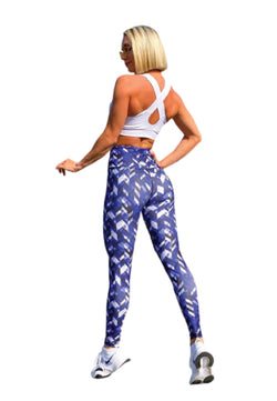 Person in einem weißen Lismina-Sportoberteil und 1037 Extra High Waist Leggings Blau & Weiss, Hand auf der Hüfte, Blick abgewandt.