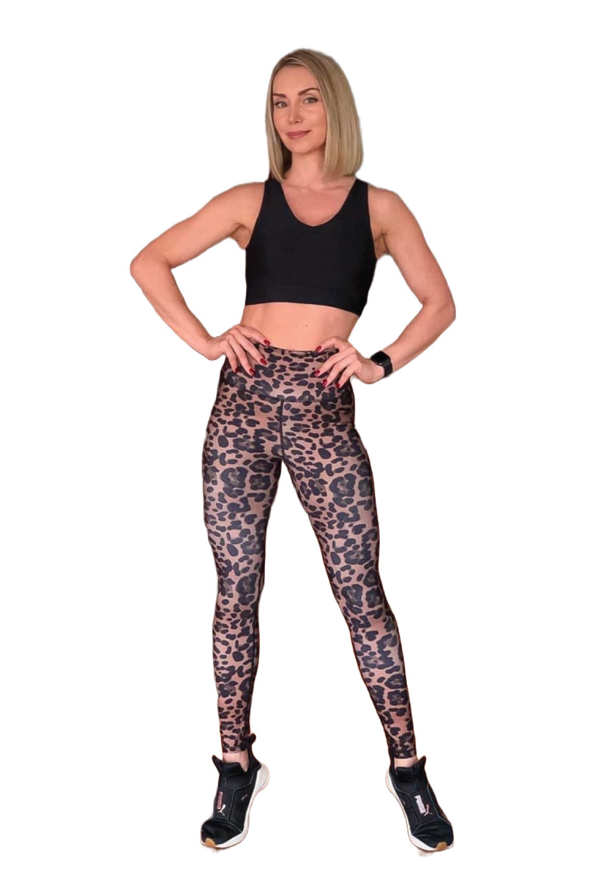Eine Frau in einem schwarzen Oberteil und Lisminas 872 Extra High Waist Leopard Leggings steht selbstbewusst mit den Händen in den Hüften.